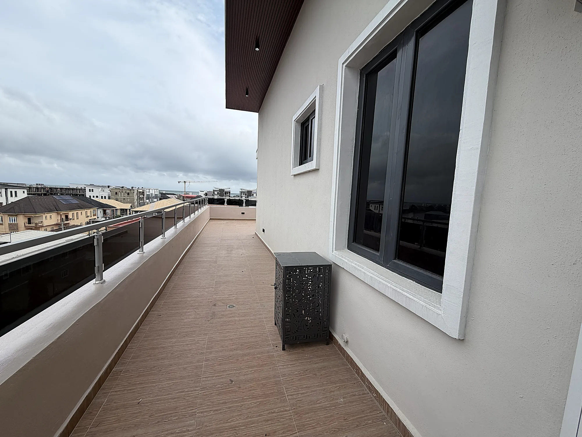 The upper terrace at Canary Penthouse, a long tiled deck with a glass balustrade